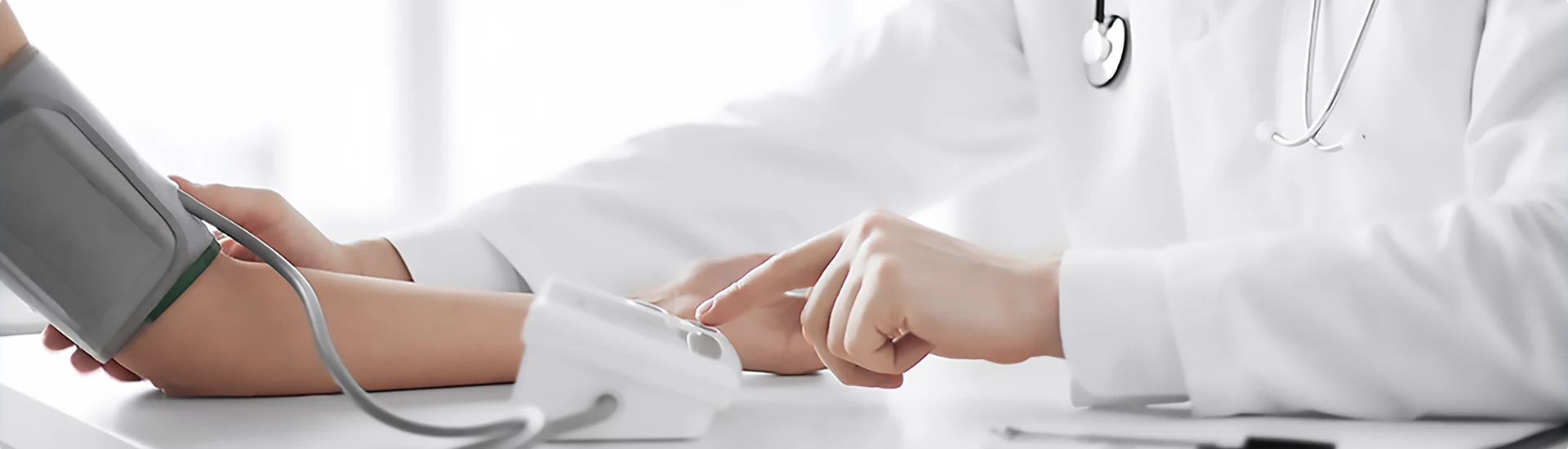 Der Arzt misst den Blutdruck beim Patienten.